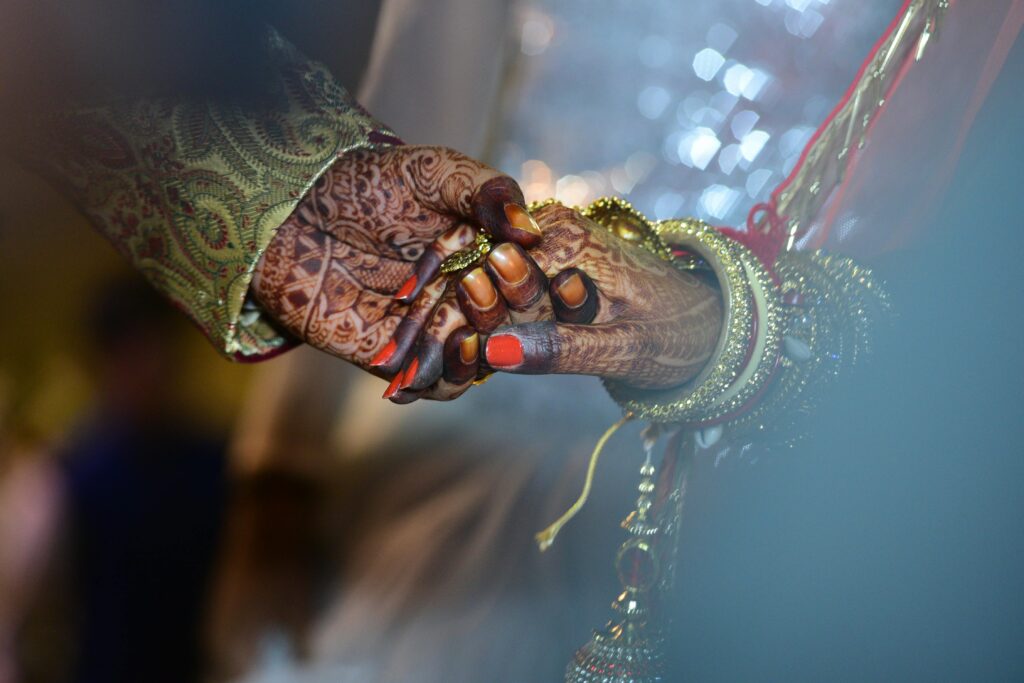 Saanvi Films A beautiful capture of mehndi-decorated hands symbolizing love and tradition in a wedding ceremony.